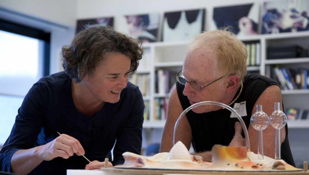 Two conservators examine a sculptural object