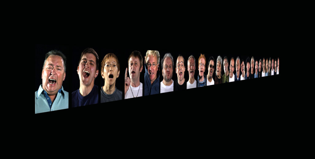 A series of faces with their mouths open are projected onto a black wall receding into the distance