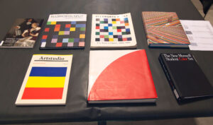 Artist books and exhibition catalogs laid out on a black surface