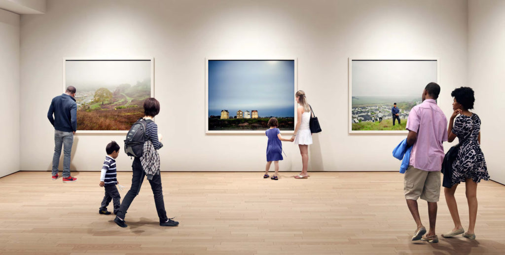 Visitors in a gallery look at large-format photography