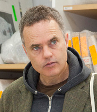A man standing in front of shelves in a studio