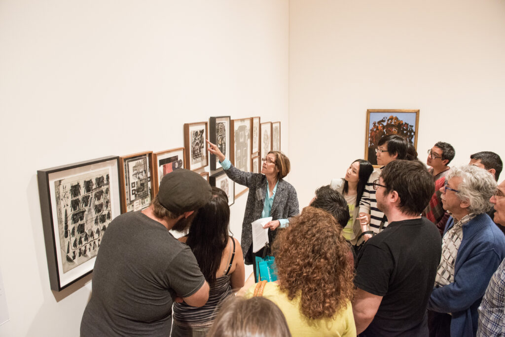 A group of people looking closely at an artwork