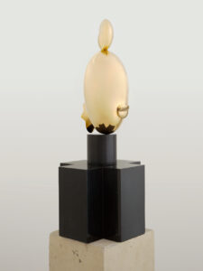 This abstract sculpture, which stands six feet tall, consists of a simple white limestone base on which sits a black marble stand, and a shiny, elongated ellipsoid bronze head. The title suggests that the figure depicted is a woman of African descent.