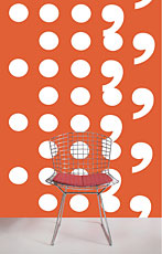 chair in front of orange wall covered in white circles and comma shapes