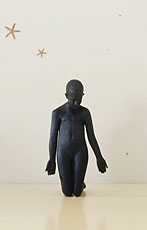 Kiki Smith; installation shot sculpture of girl kneeling with white wall and gold stars in back