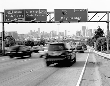 moving cars on highway under bay bridge sign
