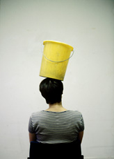 Erwin Wurm, photo of back of person balancing yellow bucket on head