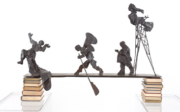 Kentridge, three animated figures walking across bridge balancing on pile of books