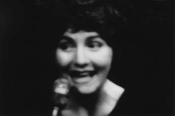 Anne McGuire, still of woman's face singing