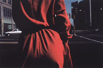 A color photograph of a woman wearing a red dress seen from below and behind, Callahan