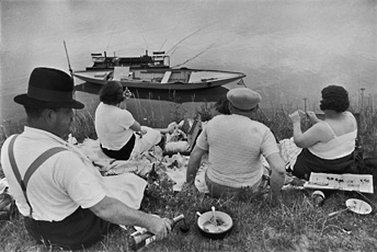 Cartier-Bresson, four people sitting on riverbed with boat 
