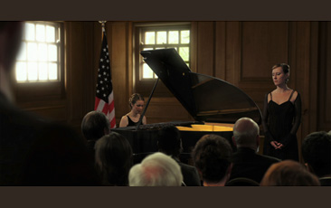 David Claerbout, video still of woman playing pianoin front of crowd and woman standing 