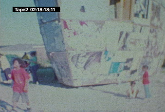 Mark Bradford, video still with two children and large structure