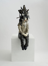 Kristalova, ceramic figure sitting wearing headdress