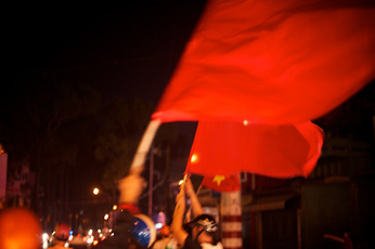 Dinh W. L, video still of crowd waving Vietnamese flag