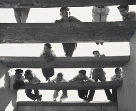 photograph of kids on slated pieces of wood from below