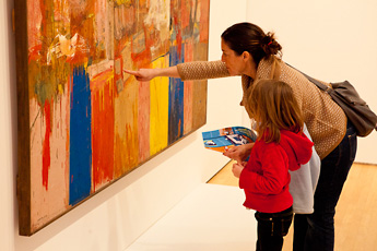 woman and young girl pointing and looking at painting