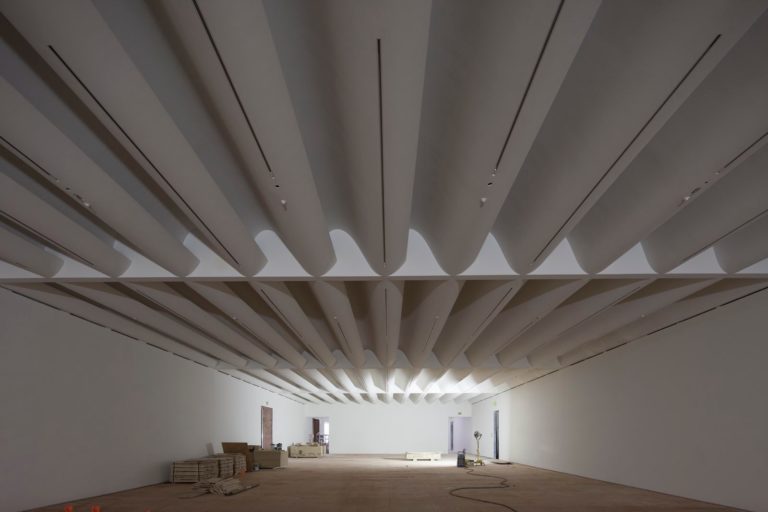 A cavernous room with an undulating white ceiling