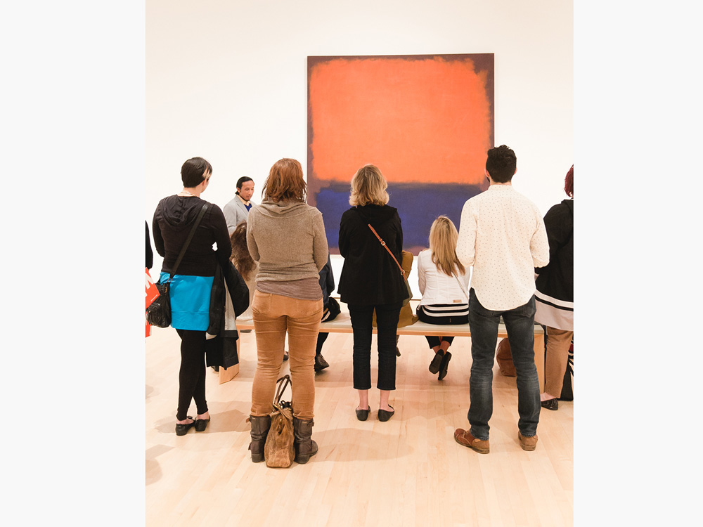 A group of people look at a painting