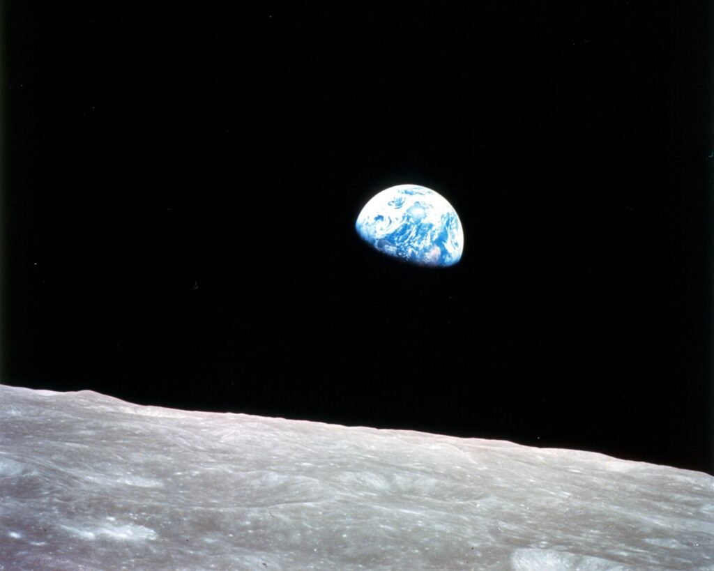 A view of the Earth rising along the horizon of the moon