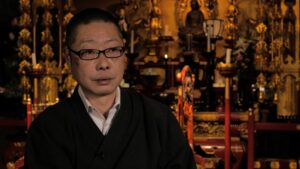 Photographer Aki Taniguchi in a Buddhist temple packed with golden adornments