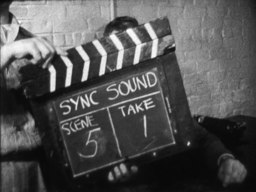Black and white film still featuring a screen marker