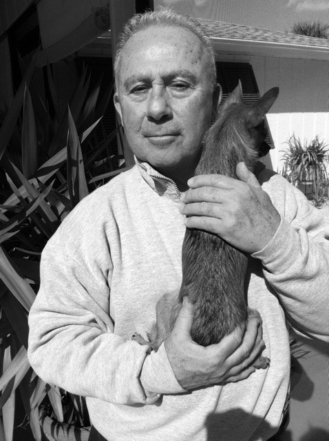 Portrait of Henry Wessel holding a small dog