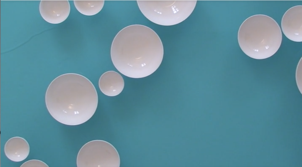 White porcelain plates, seen from above, floating in turquoise pool