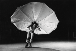 Video still of a dancer with a billowing white costume on a stage