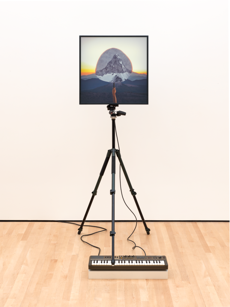 An image of a mountain mounted on a tripod standing on top of an electric keyboard, Walker Soundtracks