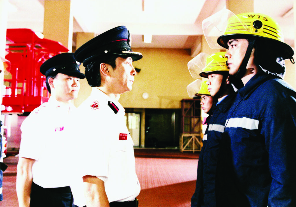 Two police officers looking at a row of firemen