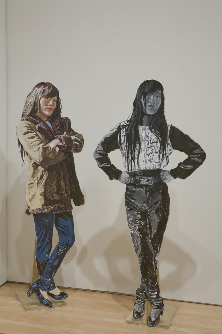 Two life-size cut outs of a woman in different poses