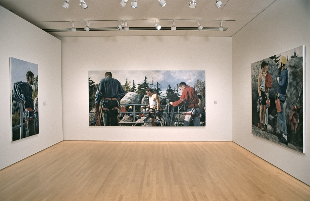 Room featuring three large paintings of rock climbers