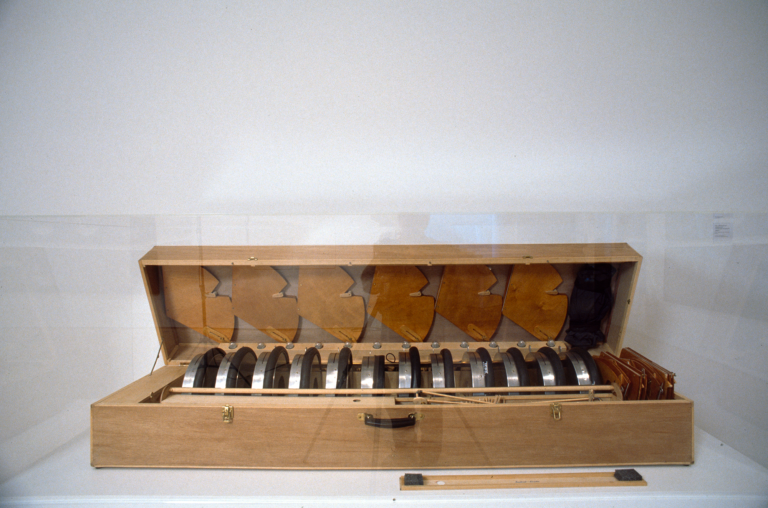 A large wooden case filled with metal and wooden objects