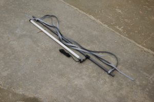 Ribbon, metal and long, thin lightbulb arranged on the floor