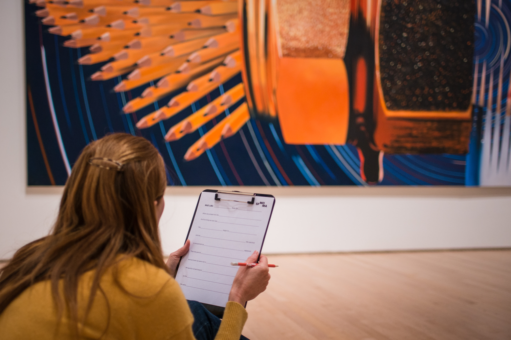 A woman looks at a Rosenquist painting