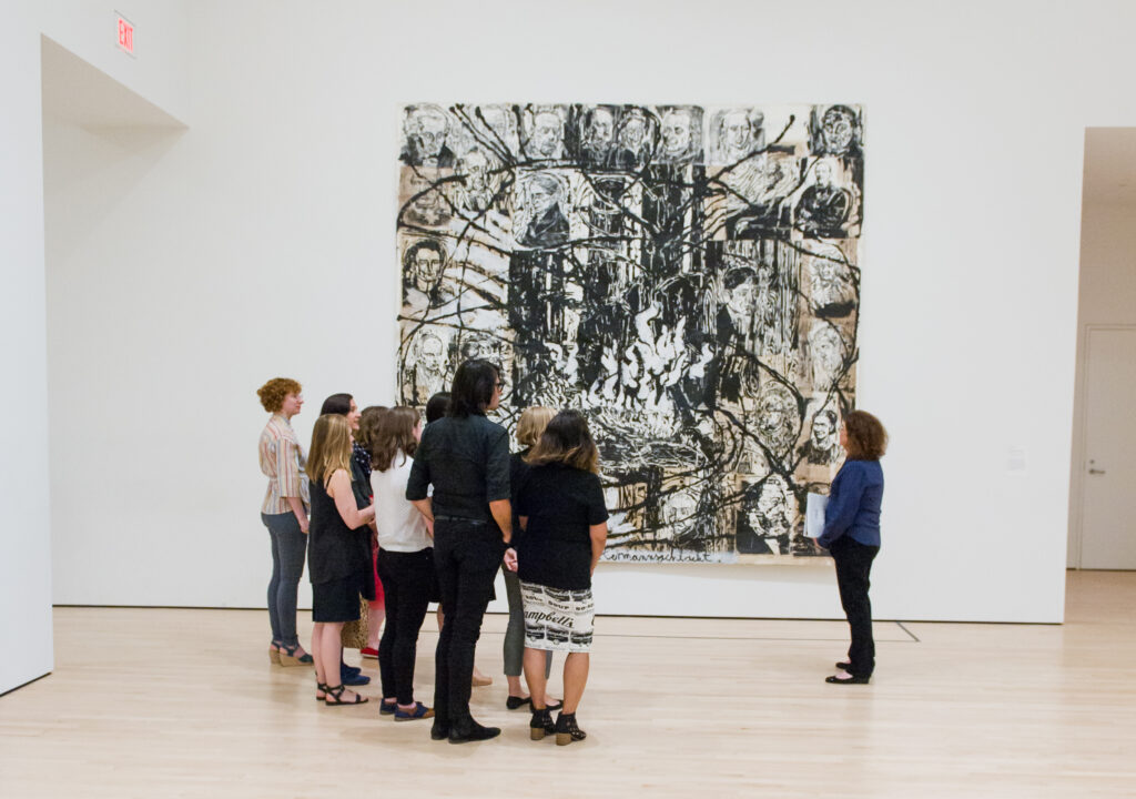 A tour group looks at a large painting by Anselm Kiefer
