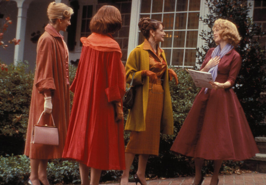 Four women from the 50s chatting in front of the house