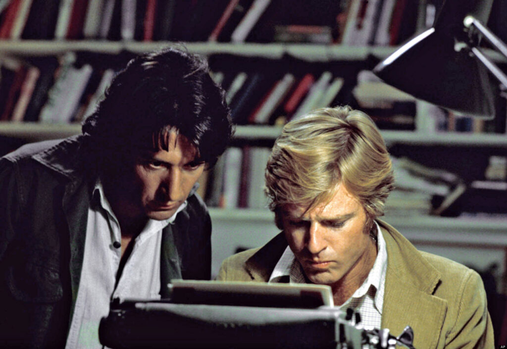 Two men looking at a typewriter