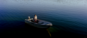 A sitting girl in a motor boat surrounded by blue water