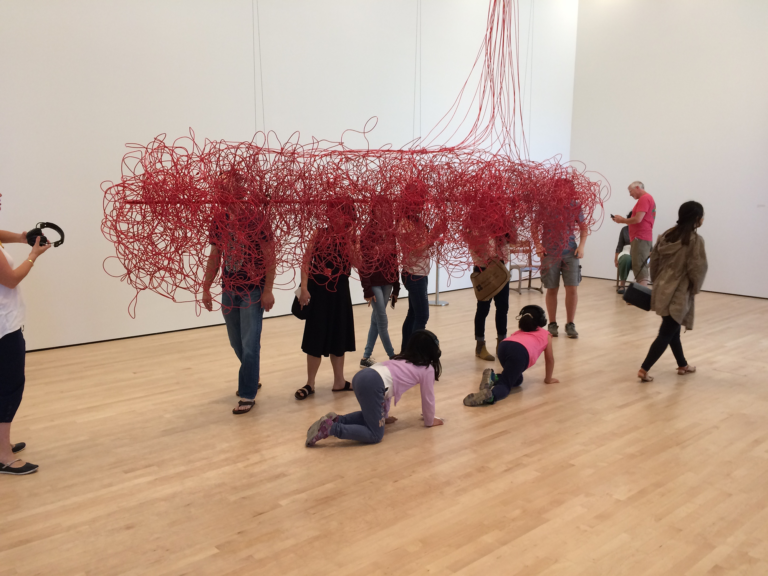 Children wearing headphones crawl underneath a cloud made of red electrical wires, Kubisch, Soundtracks