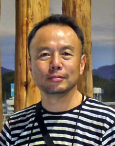 Color photograph portraying an Asian man wearing a striped shirt, Hatakeyama