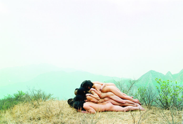 Naked bodies lying on top of each other on a mountain