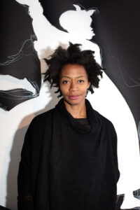 Portrait of artist Kara Walker in front of an artwork