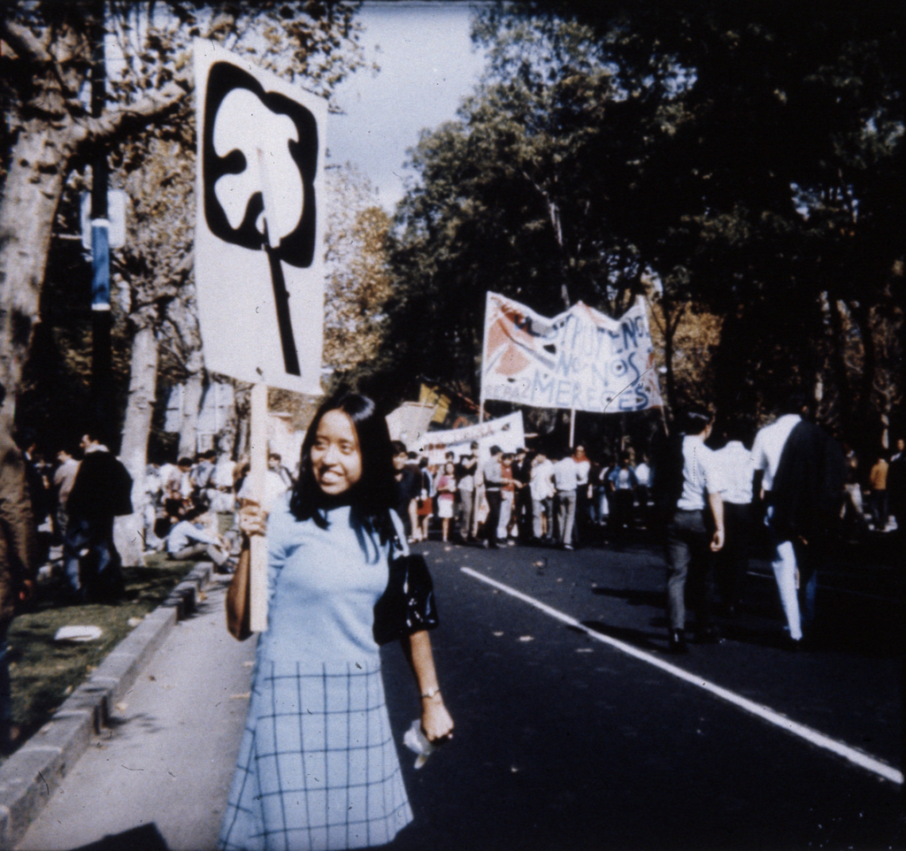 a person in sky blue attire holding a sign with symbol of dove