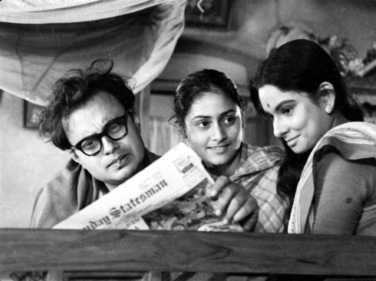 A man and two women look at a newspaper
