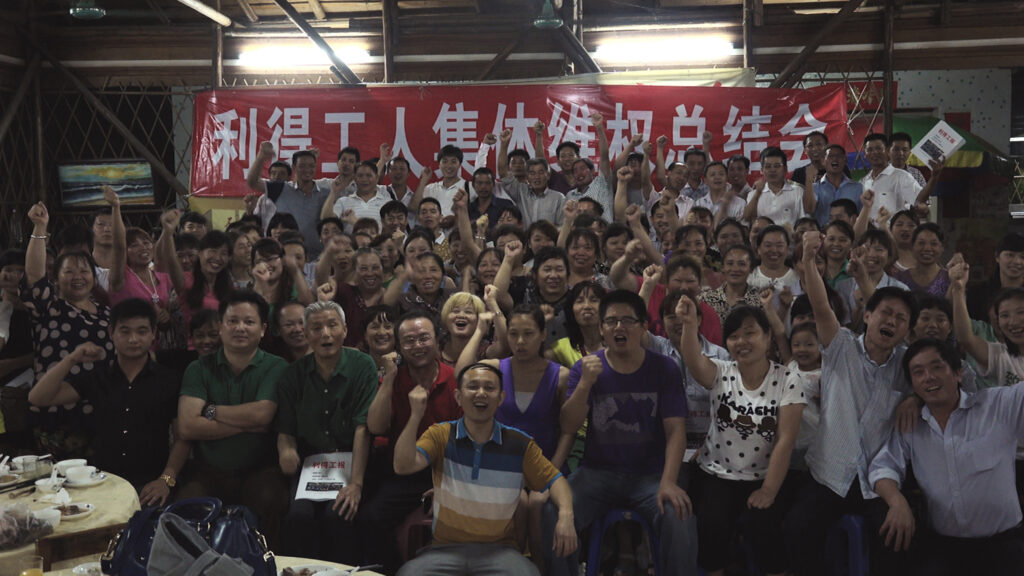 a group photo of workers with theirs fists in air