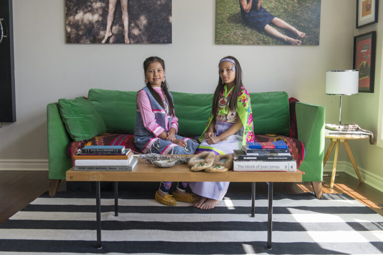 A photo of two girls sitting on a green sofa