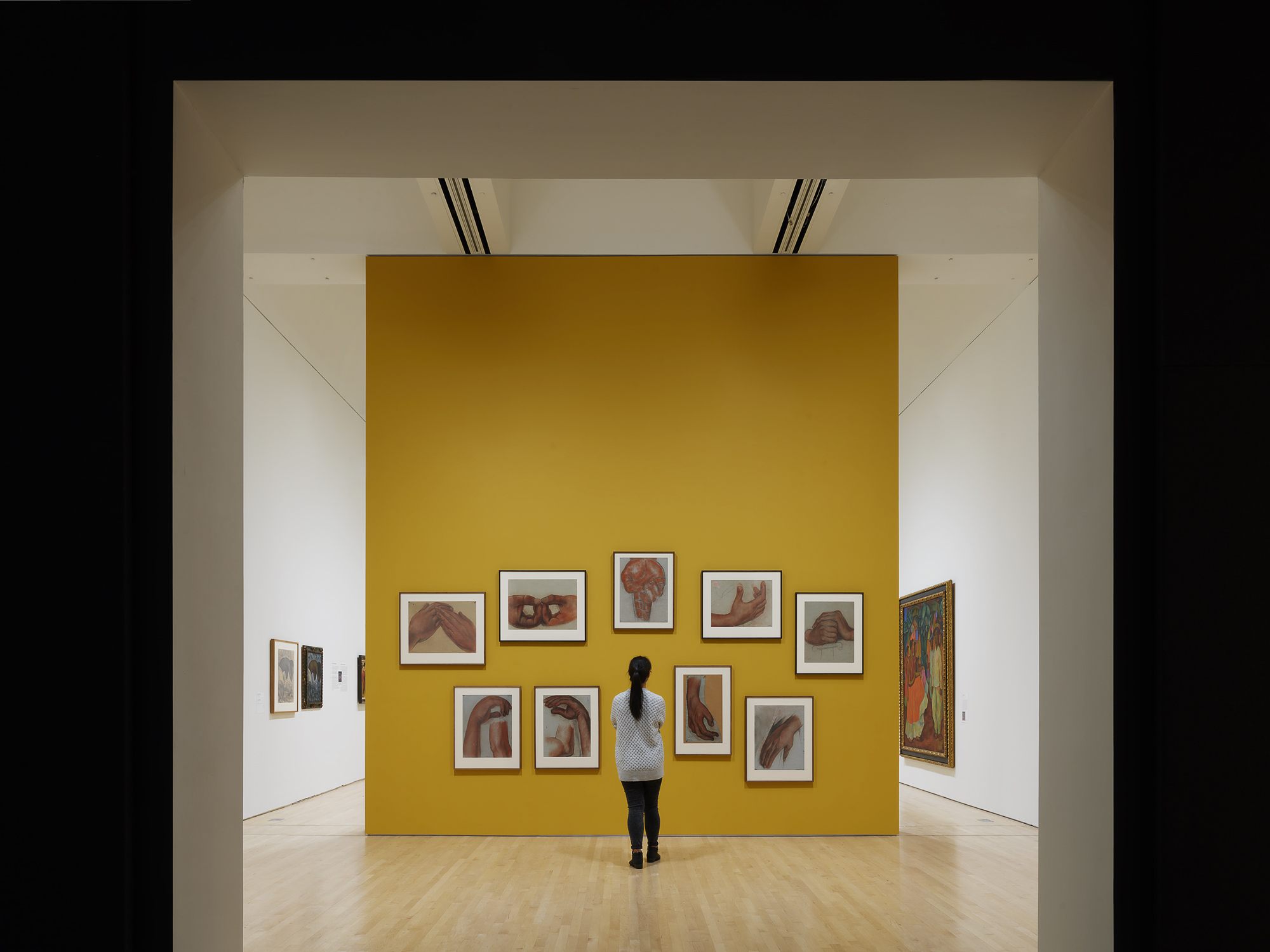 A museum visitor looks at a wall of artworks by Diego Rivera in the exhibition 